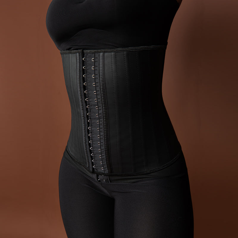 Silhouette de femme sculptée par un corset minceur en latex noir